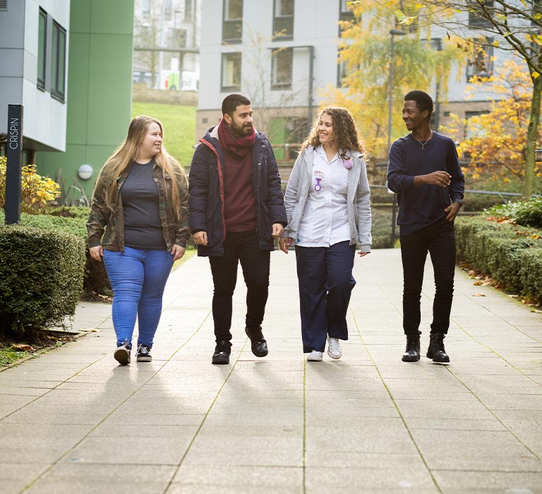 Four students walking through The Green.