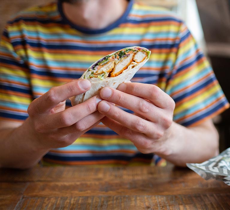 A person eating a wrap.
