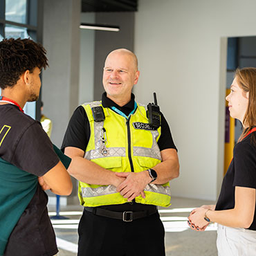 Two students chatting with campus security.