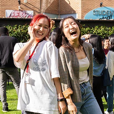 Two students laughing together on the Amp.