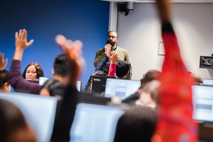 Students raising their hands in class