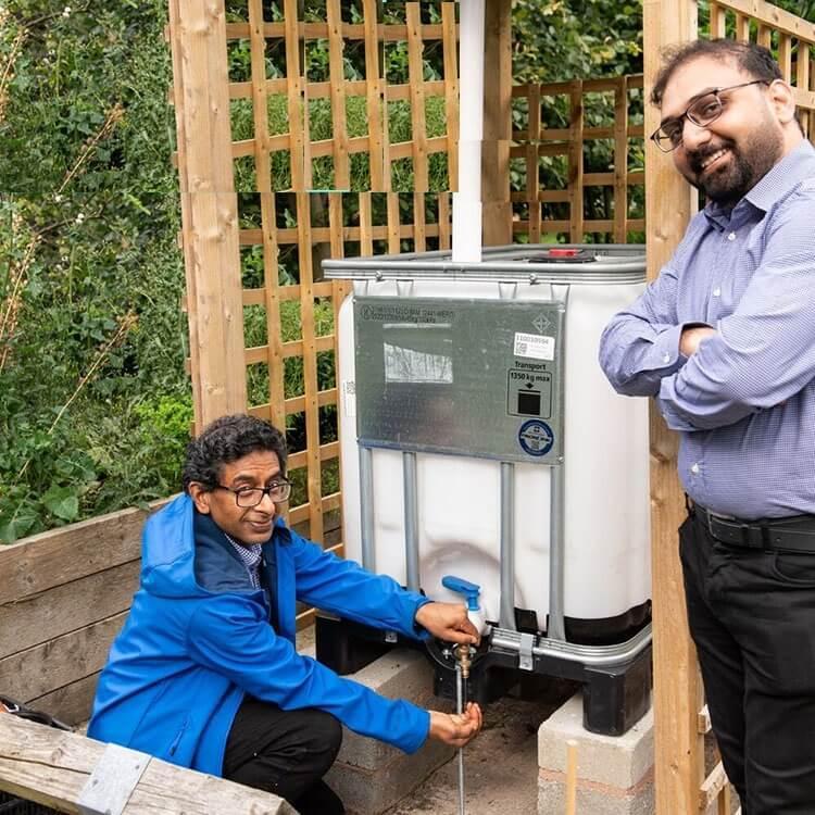 Student and staff posing in front of water reservoir