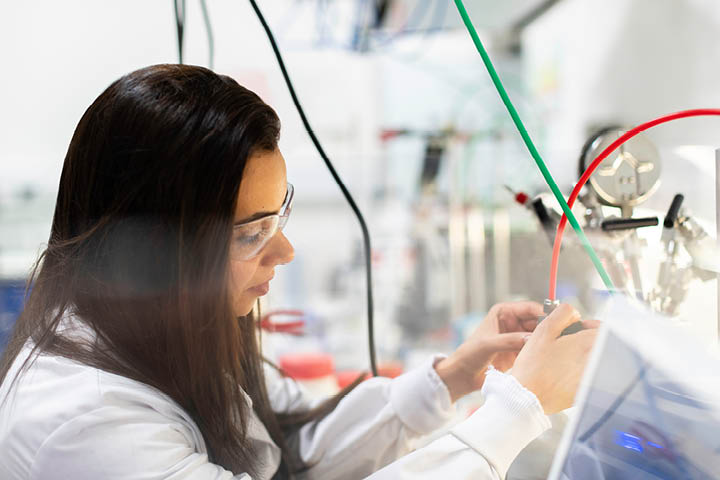 Engineering student in white coat and protective glasses