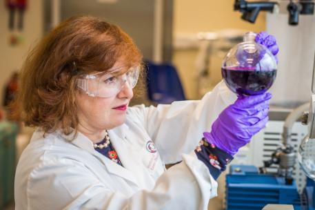 A scientist looking at a sample in a beaker