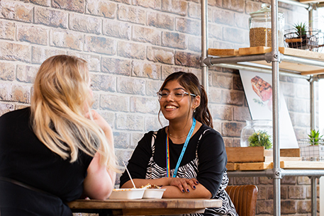 Two students chatting in the Richmond Eatery restaurant