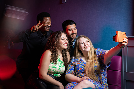 Four students taking a selfie together in the University bar