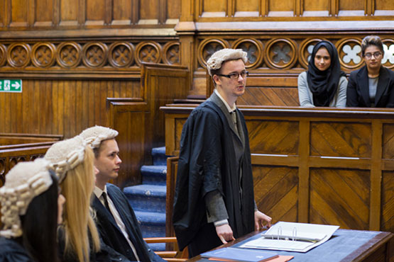 Law students taking part in a mooting session in a court room.