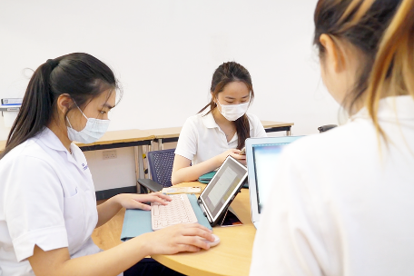 3 students working on laptops in DHEZ