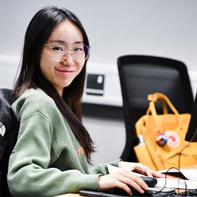 Person on a computer, looking at the camera.