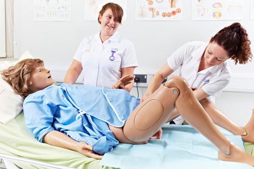 A student delivering a baby from our birthing mannequin