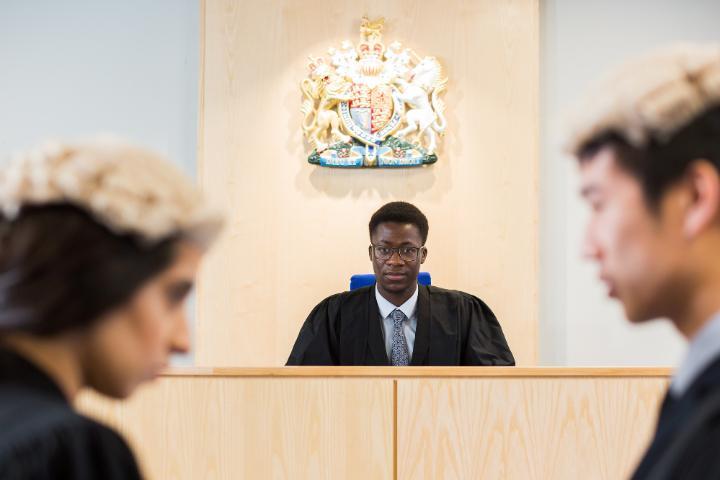 Students in wigs and gowns discussing case in front of judge in Lady Hale mock court 