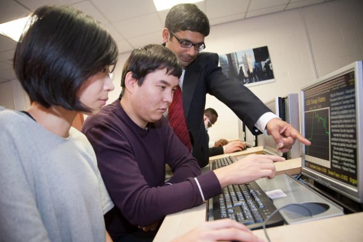 Trading room image with academic and two students