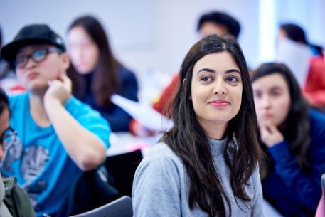 Smiling female student listens to a Career Booster presentation