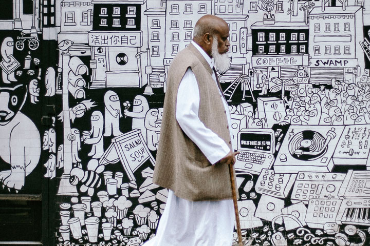 Person with walking stick at Brick Lane, London.