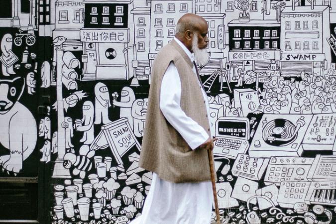 Man with walking stick at Brick Lane, London.