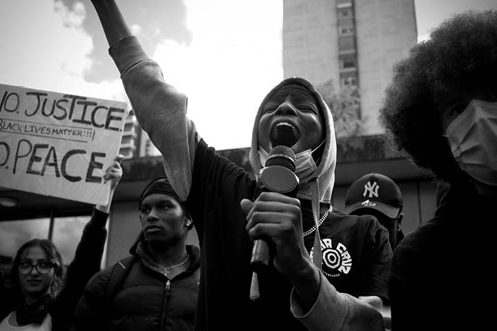 Person shouting holding microphone at Black Lives Matter protest in Manchester UK.