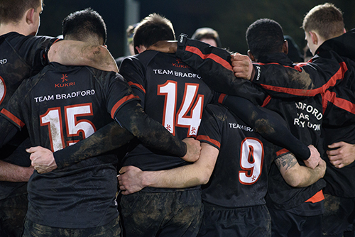 A group of students huddled during a rugby game