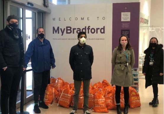 Volunteers standing besides food donations to students during lockdown