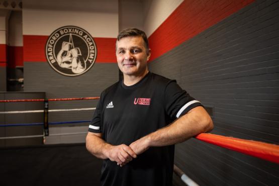 A man in a gym uniform standing in a boxing ring