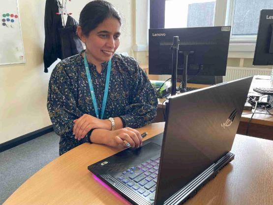 Staff member sat down at desk on laptop