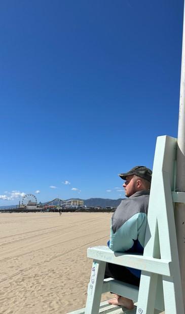 Student looking out over a sun-drenched beach