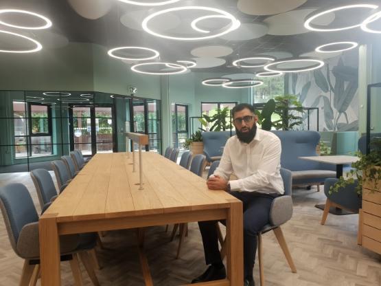 A university staff member sat at a table in a new-look university students' union area