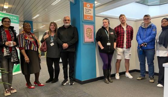 A group of students and staff standing up in a row inside library