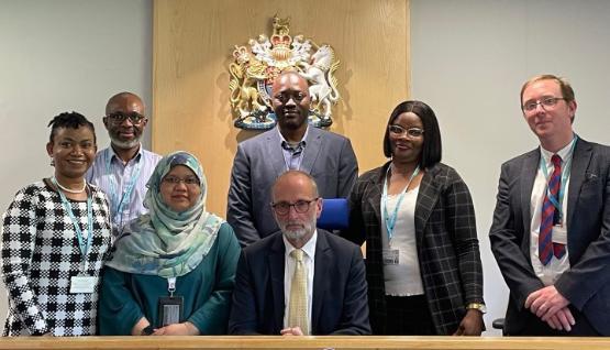 A group of university staff stood up in a courtroom behind a seated judge