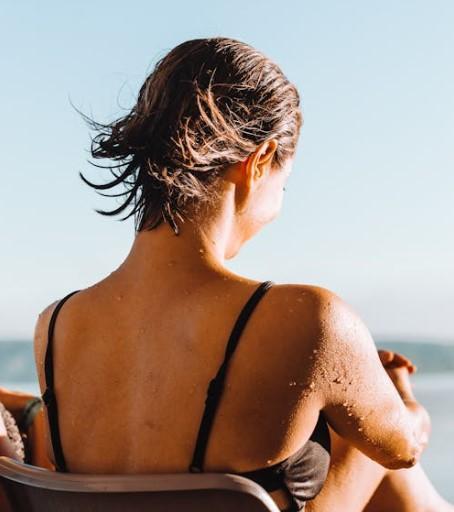 Woman sitting on beach in the sun