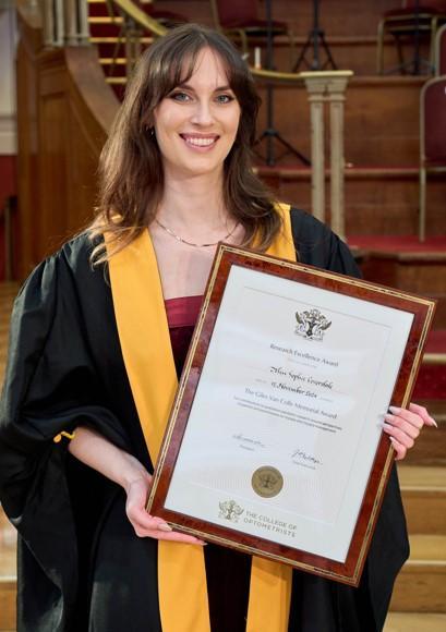 PhD Sophie Coverdale holding her award