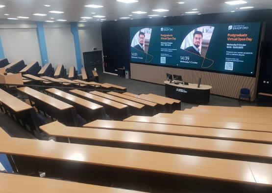 Lecture theatre with desks leading down to screen