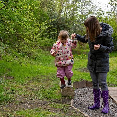 Child with Nusery staff in nature area