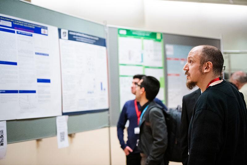 A group of people looking at poster presentations at a conference