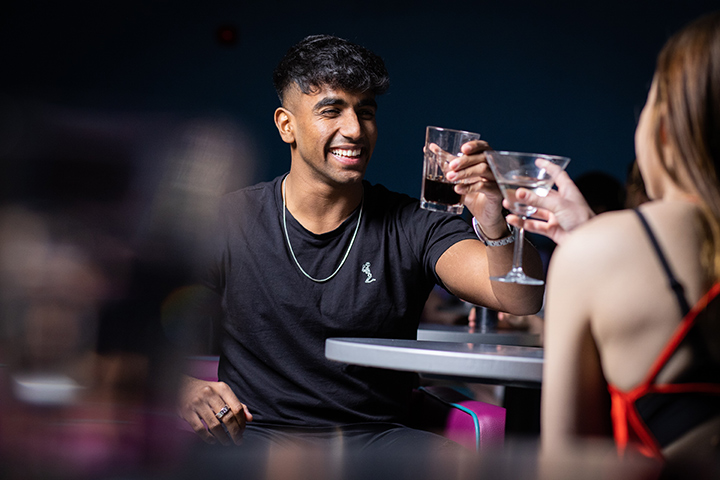 Two students having a drink in a bar on campus