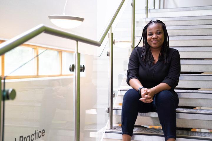 A person sitting on some stairs, smiling at the camera.