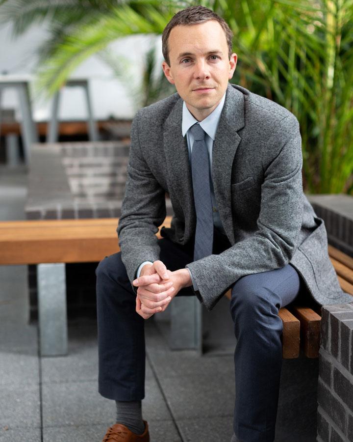 A person sitting on a bench and smiling at the camera.