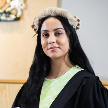 A student wearing legal uniform looks into the camera.