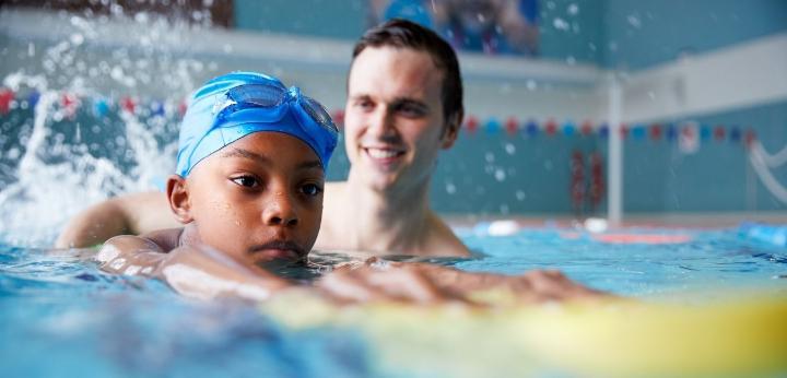 child swimming with an adult supporting the child