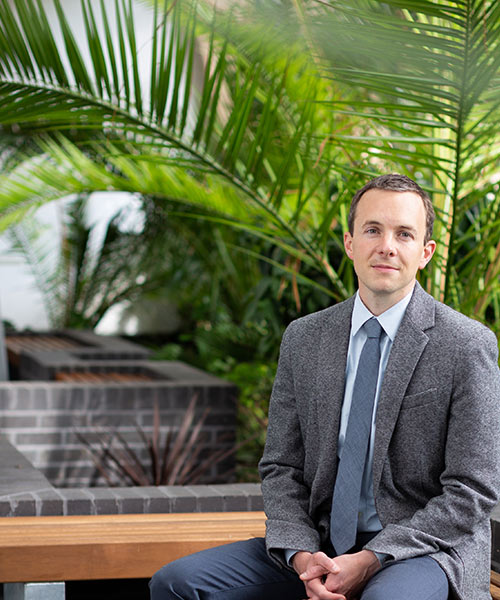 Student sat on a bench in front of plants