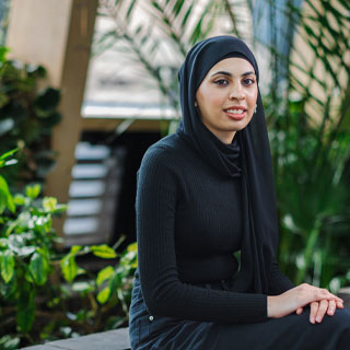 A student sitting and smiling at the camera