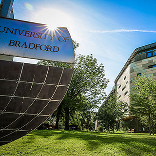 Large University of Bradford sign and the Horton Building on a sunny day. 