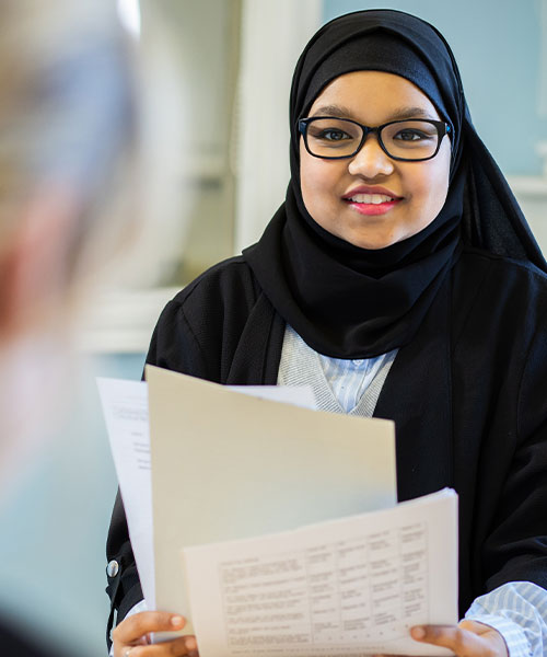 A student interviewing and smiling at the other person.